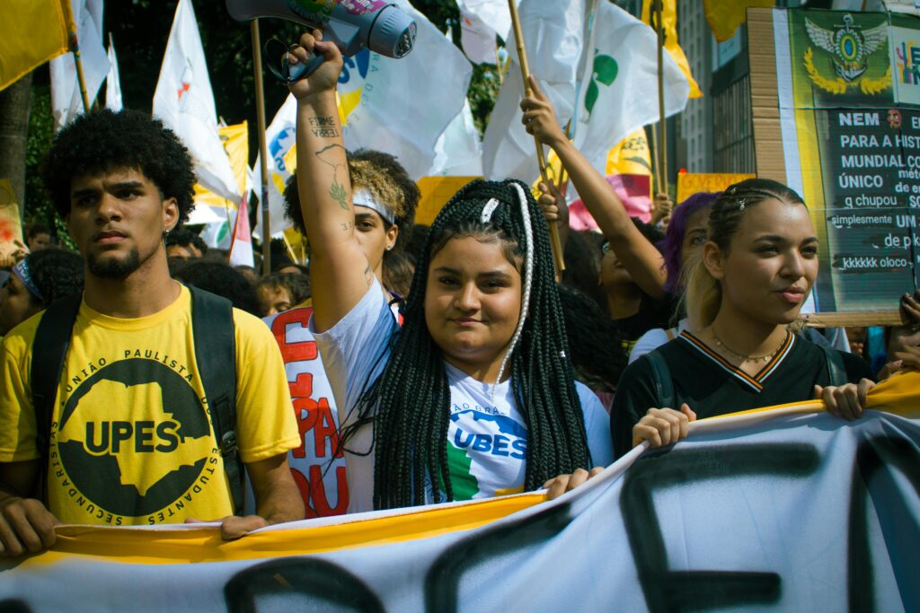 A vibrant youth protest with banners and flags, capturing activism in the urban environment.